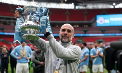 Pep Guardiola celebrates with a Manchester City trophy, used as the feature image for a legacy analysis.