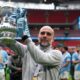 Pep Guardiola celebrates with a Manchester City trophy, used as the feature image for a legacy analysis.